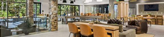 A modern open space with a dining area and a kitchen in the background.