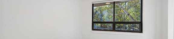 A room with a large window and a wooden floor.