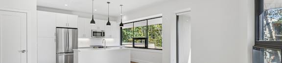 A modern kitchen with a refrigerator, sink, and cabinets.