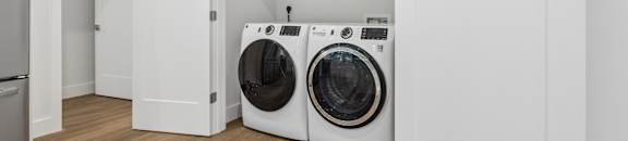 A white laundry room with a washer and dryer.