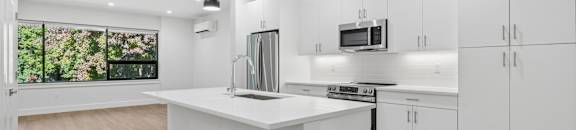 A modern kitchen with white cabinets and a central island.
