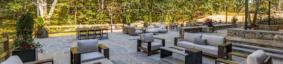 A patio with a stone floor and furniture.