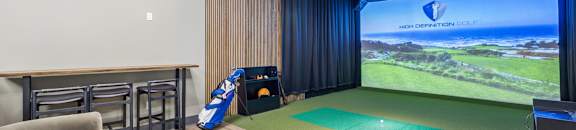 A room with a large screen and a green mat on the floor.