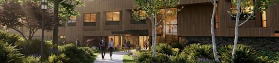 A modern building with a curved wooden exterior and a pathway leading to it.