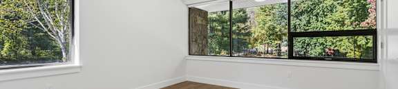 A room with a large window and wooden flooring.