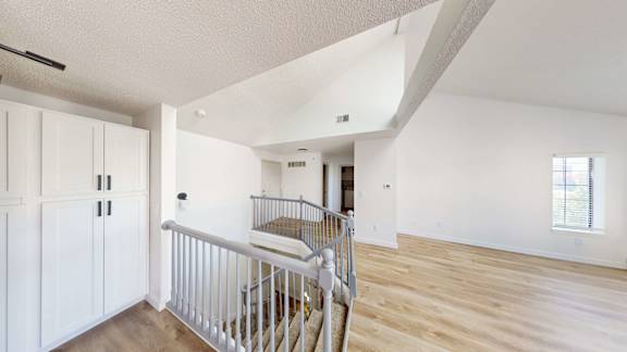 A white interior with a staircase and a window.