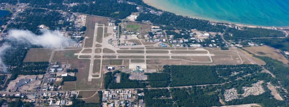an aerial view of the airport with the ocean in the background