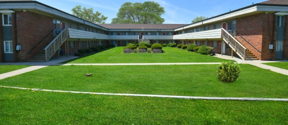 a courtyard in front of a building with green grass