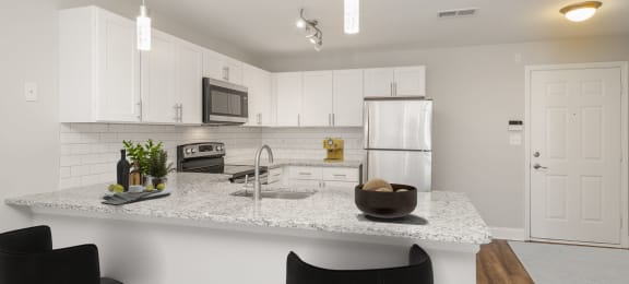 a kitchen with white cabinets and a granite counter top