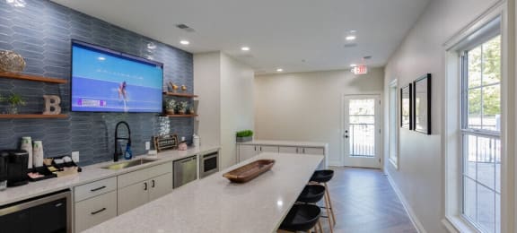 a kitchen with a long counter and a tv in a house