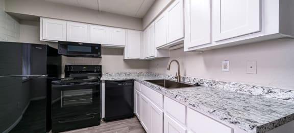 a kitchen with white cabinets and black appliances and granite counter tops at Westmount at Downtown Tempe, Tempe, 85281