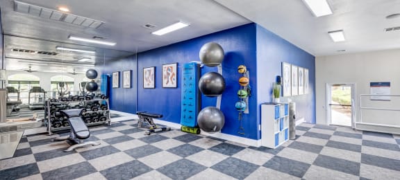 a spacious fitness center with a checkered floor and blue walls