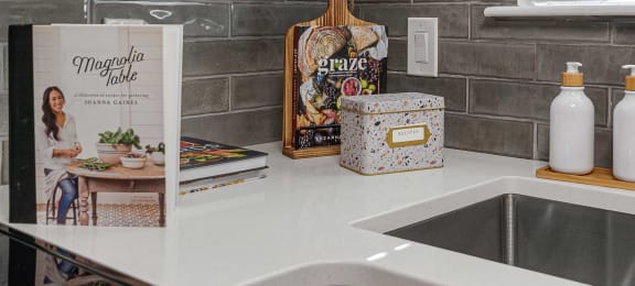 a kitchen counter with a sink and a book on the counter