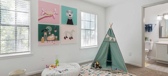 a bedroom with a teepee and pictures on the wall