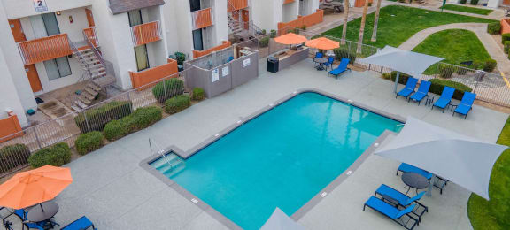 an aerial view of a swimming pool with chairs and umbrellas