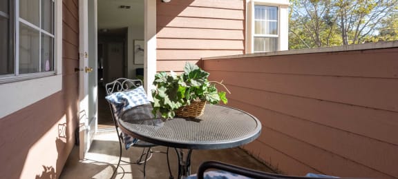 a front porch with a table and chairs and a potted plant