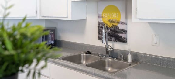 a kitchen with a sink and a sign on the wall above it
