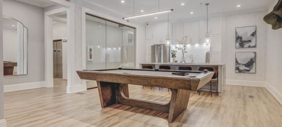 a pool table in a living room with a kitchen