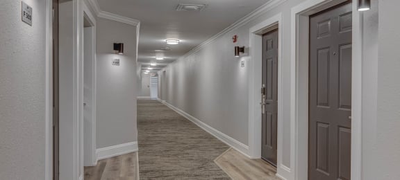 a corridor with grey doors and white walls