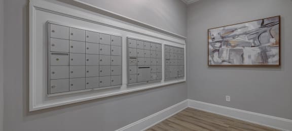 a wall of lockers in a room with hardwood floors and a painting on the wall