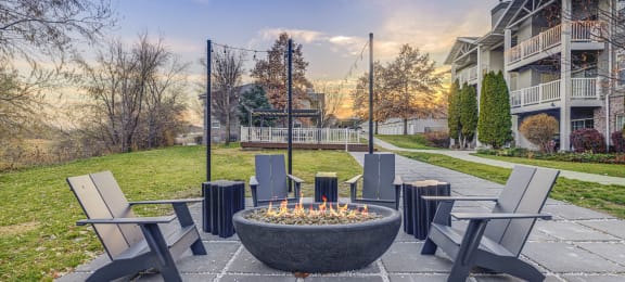 an outdoor patio with a fire pit and chairs