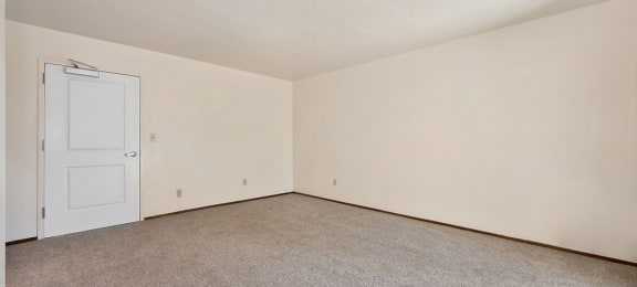 a bedroom with beige carpet and a white door
