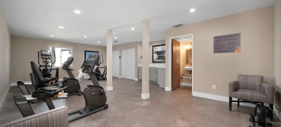 a spacious fitness room with treadmills and elliptical trainers