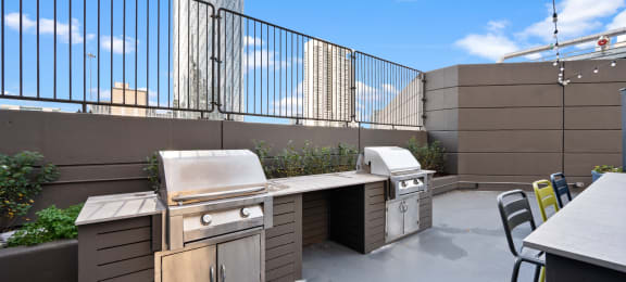 a patio with a grill and a table with chairs on it at Presidential Towers, Chicago, IL