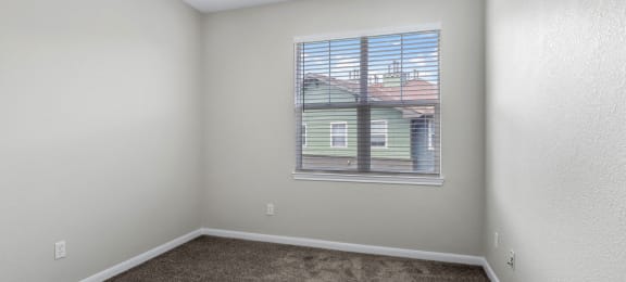 an empty room with carpet and a window  at Switchback on Platte Apartments, Littleton, CO 80120