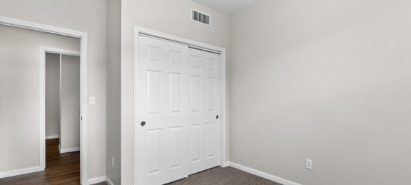 a bedroom with a white door and a door to a closet at Switchback on Platte Apartments, Littleton, 80120