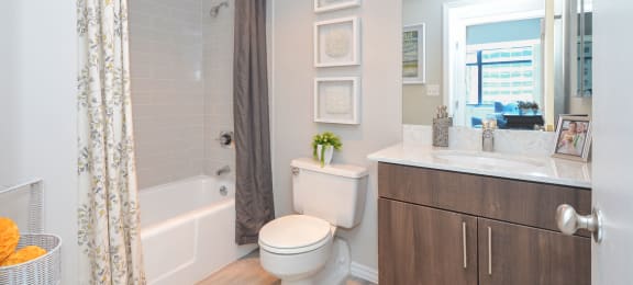 a bathroom with a shower and a toilet and a sink at Apartments at Denver Place, Denver