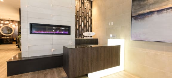 the lobby of a hotel with a reception desk and a fireplace  at Apartments at Denver Place, Denver Colorado