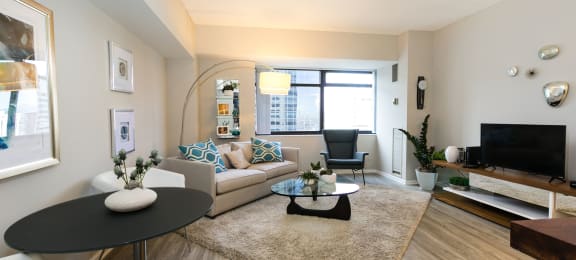 a living room with a couch and a table and a television at Apartments at Denver Place, Colorado, 80202