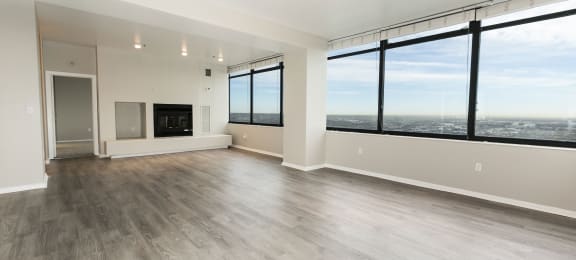 the living room of an apartment with a large window overlooking the city  at Apartments at Denver Place, Denver, CO