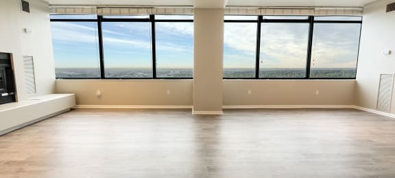 an empty living room with a window view of the city at Apartments at Denver Place, Denver, CO 80202