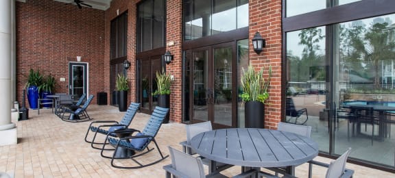 a patio with a table and chairs outside of a brick building