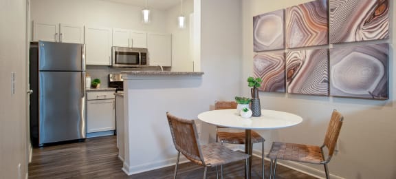 a kitchen with stainless steel appliances and a table with chairs