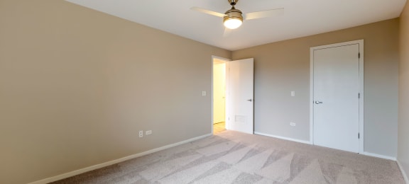 a spacious bedroom with carpet and a ceiling fan at Willow Hill Apartments, Justice, IL, 60458