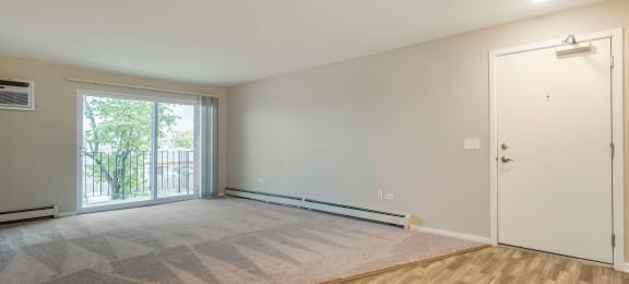 an empty living room with a door to a balcony at Willow Hill Apartments, Justice, IL, 60458