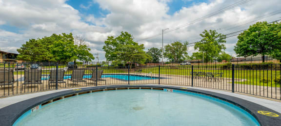 an oval swimming pool with chairs and a fence around it at Willow Hill Apartments, Justice, IL, 60458
