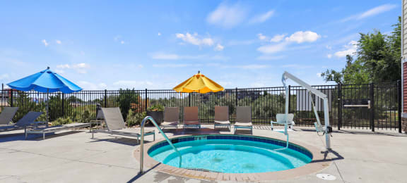 our resort style swimming pool is next to the patio and umbrellas at Ridge at Thornton Station Apartments, Thornton, 80229