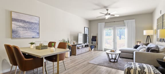 an open living room and dining room with a table and chairs at Ridge at Thornton Station Apartments, Thornton, CO 80229