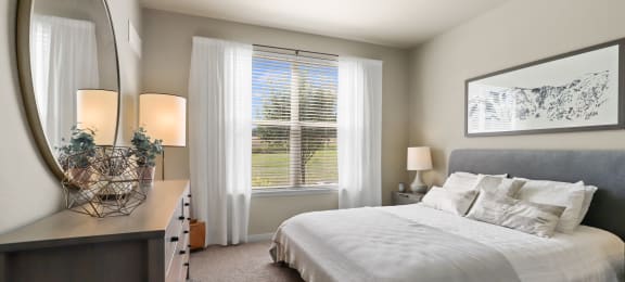 a bedroom with a large bed and a mirror at Ridge at Thornton Station Apartments, Colorado, 80229