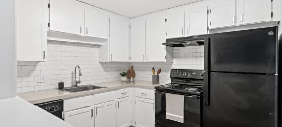 a kitchen with black appliances and white cabinets at Rosemont Square, Randolph, Massachusetts