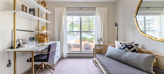 a bedroom with a bed and a desk and a window at Ashford Green, North Carolina