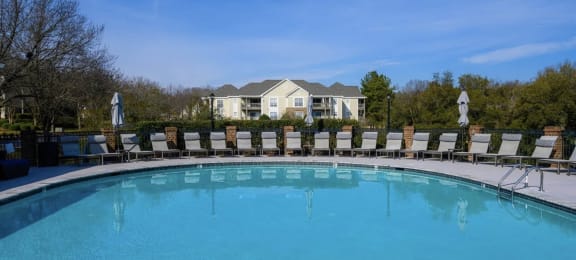 a swimming pool with chairs and a house in the background at Ashford Green, North Carolina, 28262