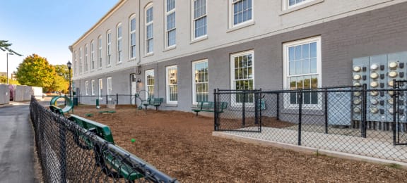 a building with a fenced in yard and a chain link fence at Highland Mill Lofts, Charlotte, NC