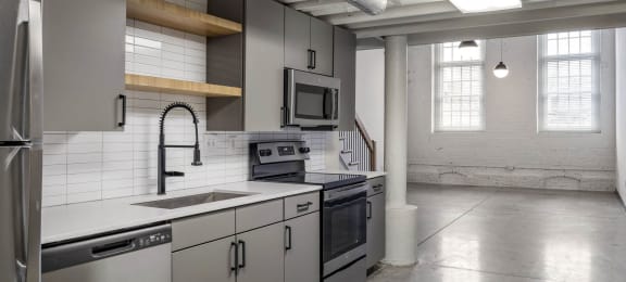 a kitchen with white counter tops and stainless steel appliances at Highland Mill Lofts, Charlotte, 28205