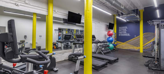 a gym with cardio equipment and weights in a building at Highland Mill Lofts, Charlotte