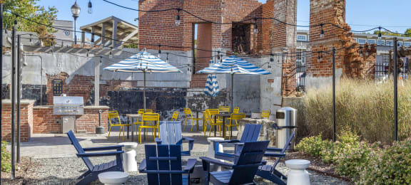 a patio with blue and yellow chairs and umbrellas at Highland Mill Lofts, Charlotte, North Carolina
